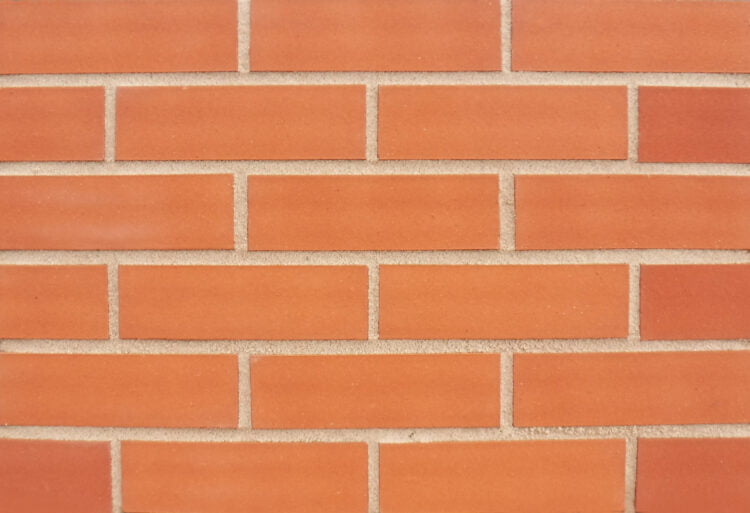 A display panel of bricks laid in a stagger bond. The panel is pointed in a mid sandstone to compliment the light orange, sand textured brick slips.