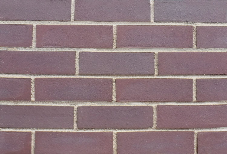 A display panel of brick slips. The bricks are a mid brown colour with an unsanded finish. The panel has been pointed in a light brown pointing mortar.